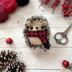 a crocheted hedge is sitting next to some pine cones and other christmas decorations