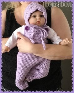 a woman holding a baby wearing a crocheted hat and scarf