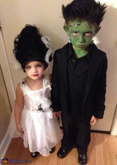 two children dressed up in costumes standing next to each other on the floor with their faces painted green