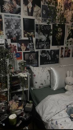 a bedroom with many pictures on the wall and a bed in front of it,