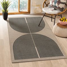 an area rug with black and white circles on it in a living room next to a potted plant