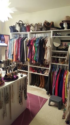 a closet with lots of clothes and shoes hanging on the wall next to a counter