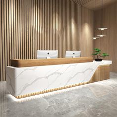 an office lobby with marble counter tops and wood paneling, along with two laptops on the desk