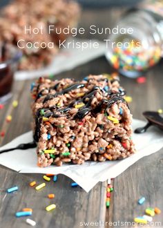 chocolate fudge sundae bars with sprinkles on the table next to it