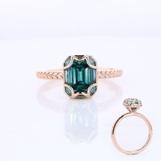 an emerald colored ring with a diamond on the side and a gold band around it