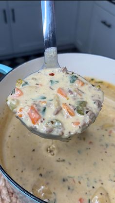 a ladle full of soup being held by a spoon