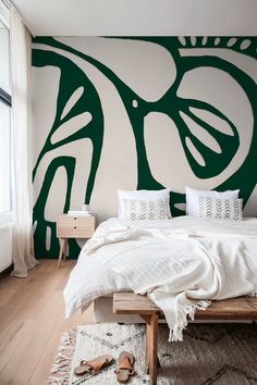 a bedroom with green and white wallpaper on the walls