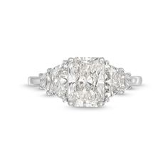 three stone diamond ring in white gold with diamonds on the sides and an oval shaped center