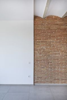 an empty room with a brick wall and floor