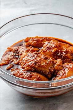 a glass bowl filled with meat and sauce