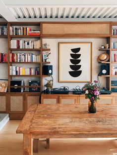 a wooden table sitting in front of a book shelf filled with books