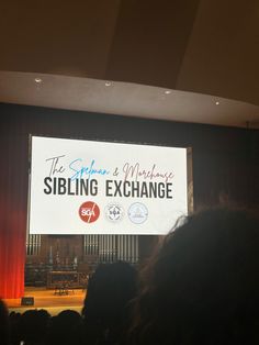 a large screen with the words sibling exchange on it in front of a group of people