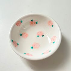 a white bowl with pink flowers painted on it