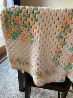 a crocheted blanket sitting on top of a chair