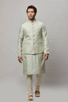 Cotton Linen blended kurta with floral ivory thread & gold sequence intertwined embroidered vest plus ivory churidar. The cotton-linen blend makes it one of our lightest and most breathable kurtas. Crafted with a collar neckline, full sleeves, and front button closure. Occasion: Can be worn to events like Sangeet, Mehendi, & Wedding WASH CARE INSTRUCTIONS - Please Dry clean only when it is applicable. Slight color variation is possible due to digital photography. Straight Kurta Nehru Jacket With Zari Work For Spring, Spring Wedding Nehru Jacket Straight Kurta, Spring Nehru Jacket With Zari Work, Spring Nehru Jacket With Zari Work, Straight Kurta Style, Spring Festive Nehru Jacket With Cutdana Details, Spring Festive Nehru Jacket With Cutdana, Spring Wedding Nehru Jacket In Chanderi, Spring Wedding Chanderi Bandhgala, Spring Wedding Bandhgala In Chanderi