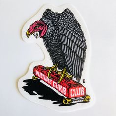 an eagle sitting on top of a skateboard with the words vulture bird club written below it