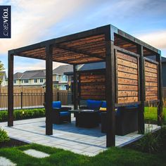 a wooden gazebo sitting on top of a lush green field