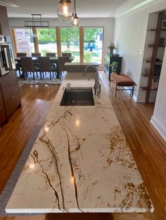 a kitchen island with marble counter tops and wooden floors