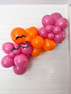 a bunch of balloons with bats on them hanging from the wall in front of a door