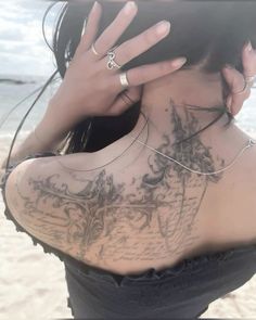 the back of a woman's neck with tattoos on it