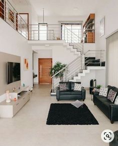 a living room filled with furniture and a stair case