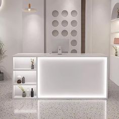 a white counter sitting in the middle of a room next to a potted plant