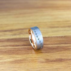 a wedding ring with birds on it sitting on a wooden table