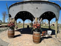 an outdoor area with several wooden barrels and flowers