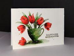 a greeting card featuring red flowers in a green vase with the words happiness on it