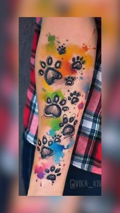 a person with a colorful tattoo on their arm and paw prints in the shape of hearts