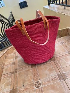 Kiondo overview A beautiful hand made kiondo bag in Cherry red color. A wonderful art piece for your everyday activities and a great gift for a loved one. The bag is made of sisal fiber that is hand picked hand prepared into yearn then twisted and weaved. It is finished with natural leather mainly from cow hide. Uses Day out: Its a great bag for use in carrying personal effects such as outdoor mats,sandals and other picnic items Shopping: The bag has large space that can adequately accommodate y Camera Bag Insert, Picnic Items, Outdoor Mats, Planter Bags, Cherry Red Color, Woven Bags, Bag Insert, Summer Handbags, Rope Bag