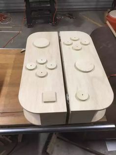 two pieces of wood sitting on top of each other in front of a table with buttons