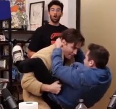 two men are hugging each other in the room