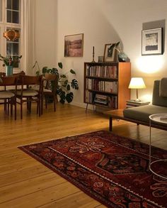 a living room filled with furniture and a large rug on top of a hard wood floor