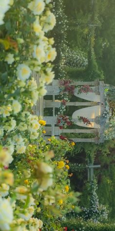 an aerial view of a garden with lots of flowers and a white bench in the middle