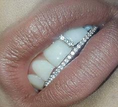 a close up view of a woman's lips with a diamond ring on her lip