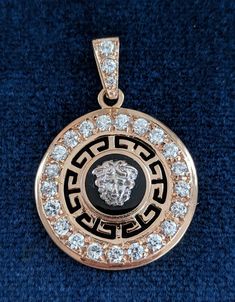 "A well made 14 karat rose gold jewelry ensemble consisting of a pendant with matching earrings for pierced ears set with cubic zirconia. The exception is a .07 carat diamond at the top of the pendant's bail, a replacement stone. The neo-classical design features Greek fret work and 14k white gold lion's faces on top of black onyx rounds. The CZ stones are .05 carats each in the pendant and .03 in the earrings. The pendant measures 1 9/16 inches high, including the bail; it is 1 1/8 in diameter. Luxury 14k Stamped Cubic Zirconia Jewelry, Luxury Brilliant Cut Medallion Jewelry, Luxury Medallion-shaped Jewelry With Brilliant Cut, Luxury Rose Gold Medallion Jewelry, Designer Brilliant Cut Cubic Zirconia Jewelry, Designer 14k Gold Jewelry With Diamond Accents, Designer Rose Gold Jewelry With Polished Finish, Designer 14k White Gold Jewelry, Designer Rose Gold Polished Jewelry