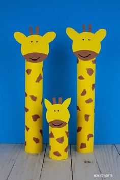 three giraffes made out of toilet paper rolls