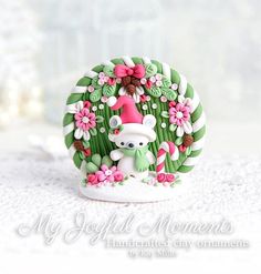 a green and white figurine with pink flowers on it