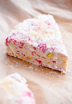 a piece of cake sitting on top of a table covered in sprinkles