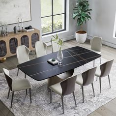 a dining room table with chairs and a potted plant