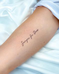 a person with a tattoo on their arm that says, surprise for pleasure in cursive writing