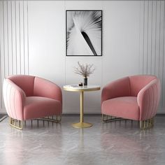 two pink chairs sitting next to each other near a table with a vase on it