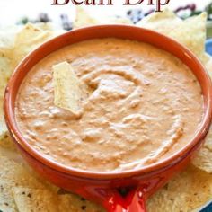 a bowl of dip on top of tortilla chips with the title, how to make bean dip