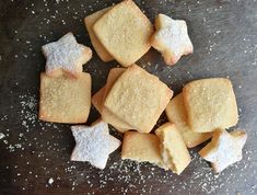 some sugar cookies are on a table with sprinkles and powdered sugar