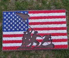 an american flag made out of crochet with the silhouette of two soldiers on it