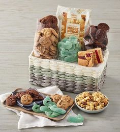 a basket filled with cookies, crackers and other treats next to a bowl of popcorn