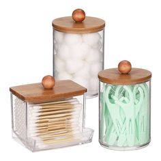 two clear containers with wooden lids filled with matches and white cotton swabs next to each other