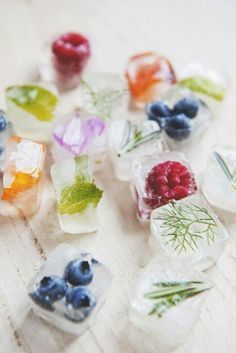 small ice cubes with berries and herbs on them