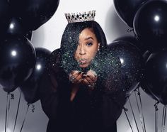 a woman wearing a tiara surrounded by balloons